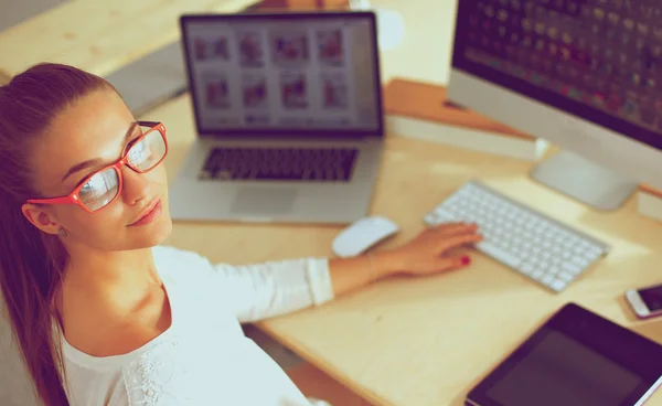 Jonge vrouw werkt in het kantoor, zit aan het bureau — Stockfoto