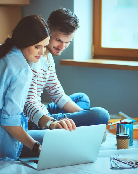 Jong koppel zittend op de vloer van hun nieuwe appartement — Stockfoto