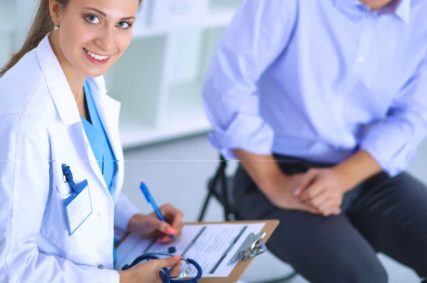 Woman doctor talking to her male patient at office — Stock Photo, Image