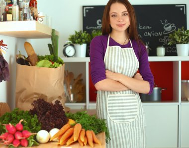 Onun mutfak masa alışveriş torbaları ile yakın duran genç kadın