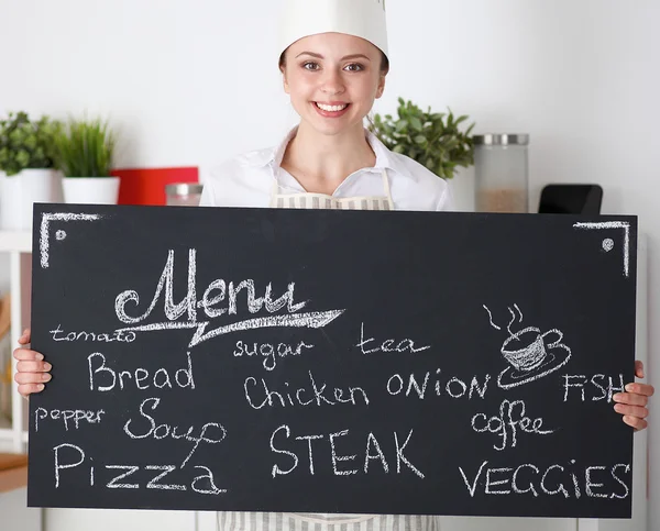Chef woman holding the menu board , standing in kitchen — Stock Photo, Image