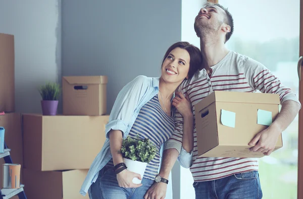 행복 한 젊은 커플 또는 상자 포장을 풀고 새로운 가정으로 이동 — 스톡 사진