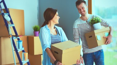 Mutlu genç çift açma veya kutu ambalaj ve yeni evine taşıdıktan