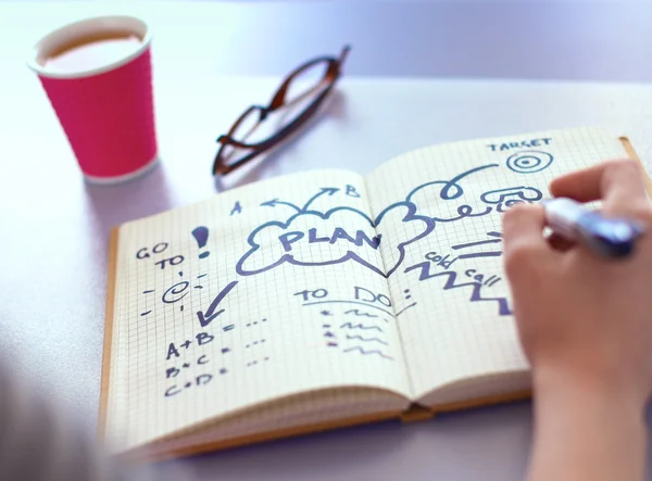 Jonge vrouw schrijft naar dagboek op een witte tabel — Stockfoto