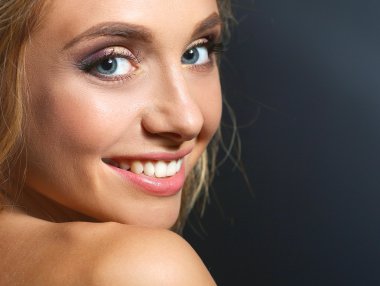 Koyu arka plan üzerinde kıvırcık uzun saçlı güzel kadın