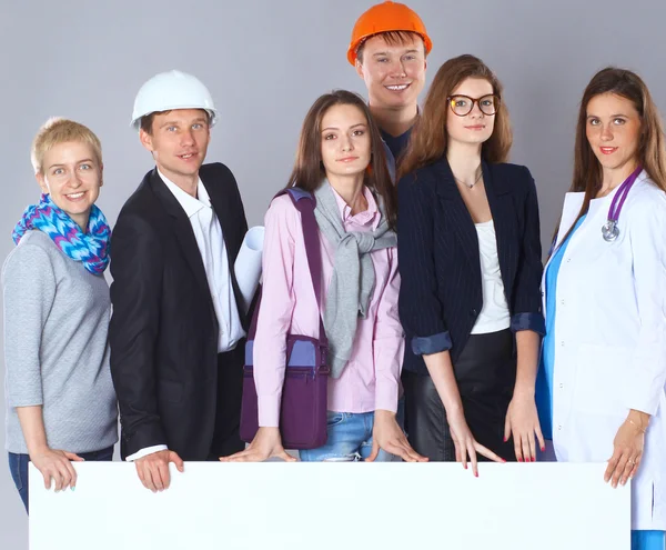 Feliz grupo de personas de diferentes profesiones con una cartelera en blanco. — Foto de Stock