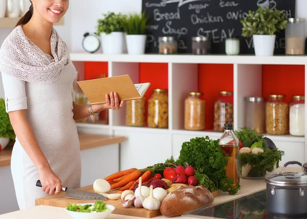 Een jonge vrouw in haar keuken koken . — Stockfoto