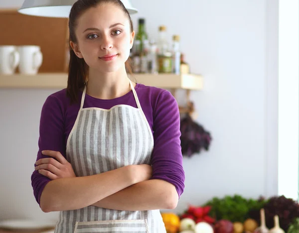 En ung kvinna som står i köket. — Stockfoto