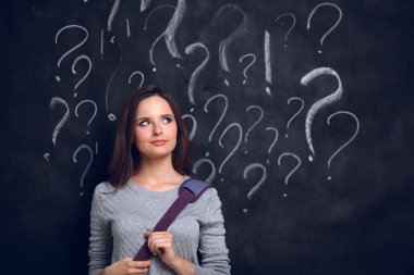 soru işareti gri bir arka plan üzerinde bulunan genç kız