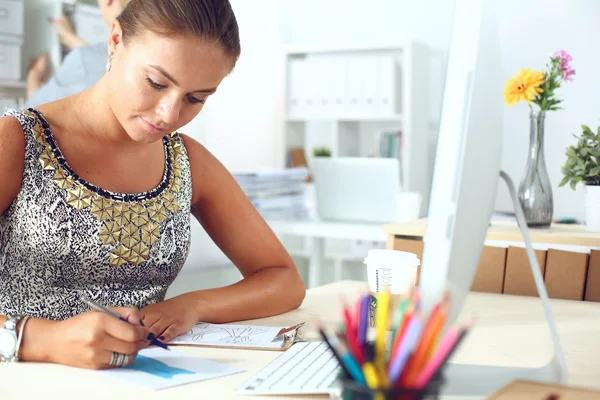 Modedesigner, die im Atelier arbeiten, sitzen am Schreibtisch — Stockfoto