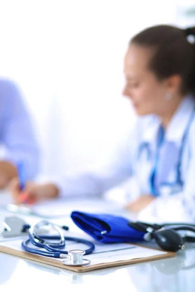 Portrait of young female doctor sitting at desk in hospital — Stock Photo, Image