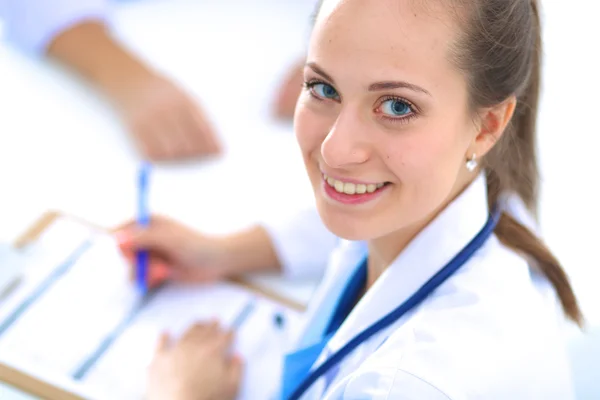 Retrato de uma jovem médica sentada à mesa no hospital — Fotografia de Stock