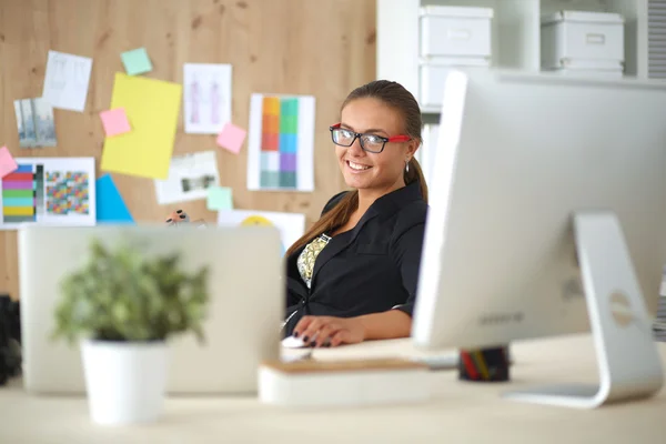 Mujer joven trabajando en la oficina, sentada en el escritorio — Foto de Stock