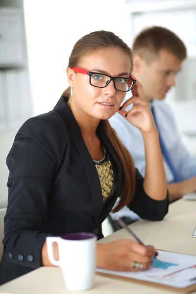 Fashion designers working in studio sitting on the desk — Stock Photo, Image