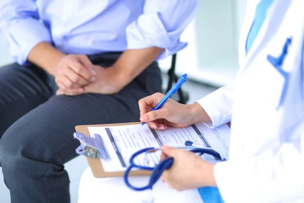 Médecin femme assise avec un patient masculin au bureau — Photo