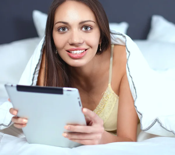 Vrouwen gebruiken een tablet pc op het bed — Stockfoto