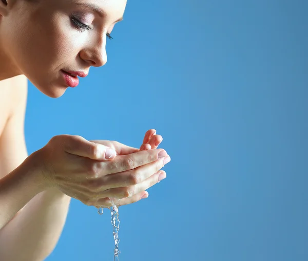 Junges Weibchen wäscht ihr Gesicht mit klarem Wasser — Stockfoto