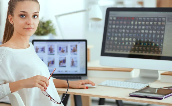 Mujer joven trabajando en la oficina, sentada en el escritorio — Foto de Stock