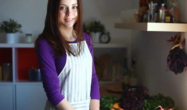 Junge Frau steht mit Einkaufstaschen in ihrer Küche neben Schreibtisch — Stockfoto