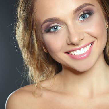 Koyu arka plan üzerinde kıvırcık uzun saçlı güzel kadın