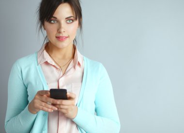 Akıllı telefon kullanan ve okuyan bir kadın