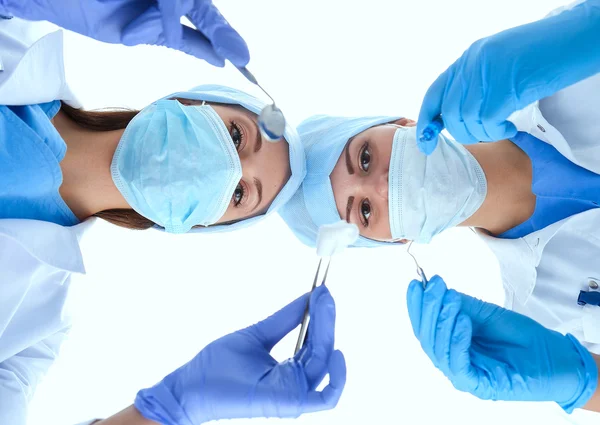 Squadra di chirurghi, uomo e donna con uniformi protettive, berretti e maschere — Foto Stock