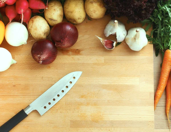 Mutfaktaki masanın üstünde sebzeler var.