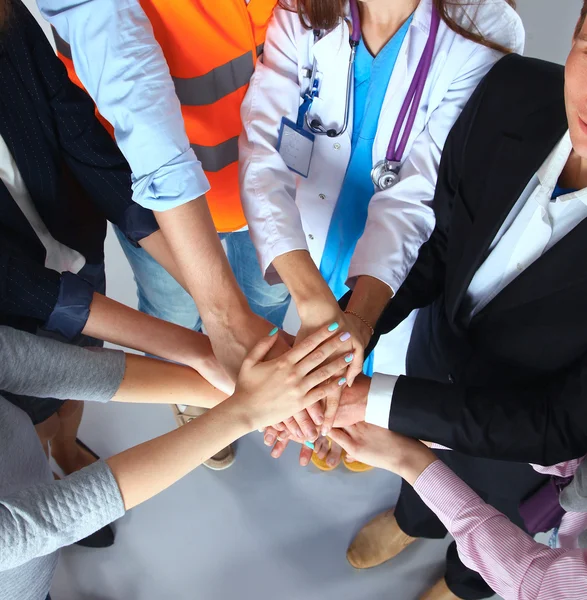 Portrait of people with various occupations putting their hands on top of each other — Stock Photo, Image