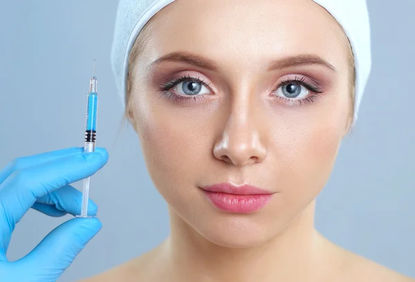 Inyección cosmética en la cara de la mujer bonita. Aislado sobre fondo gris — Foto de Stock