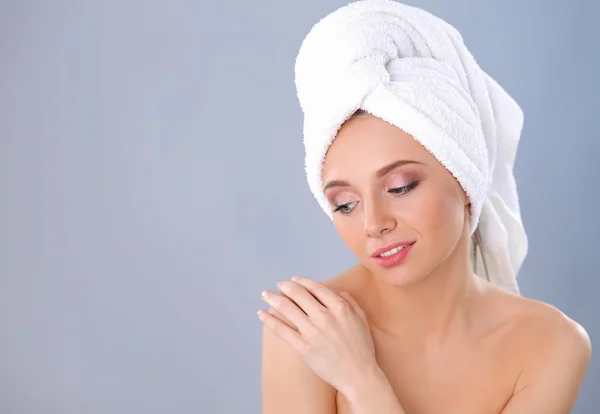 Beautiful woman with a towel on her head on a gray background — Stock Photo, Image