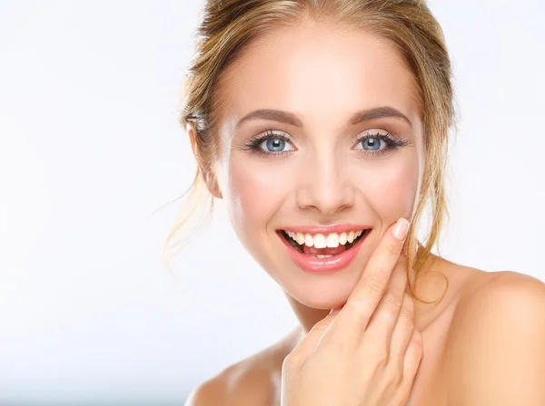 Giovane donna che tocca il suo viso isolato su sfondo bianco — Foto Stock