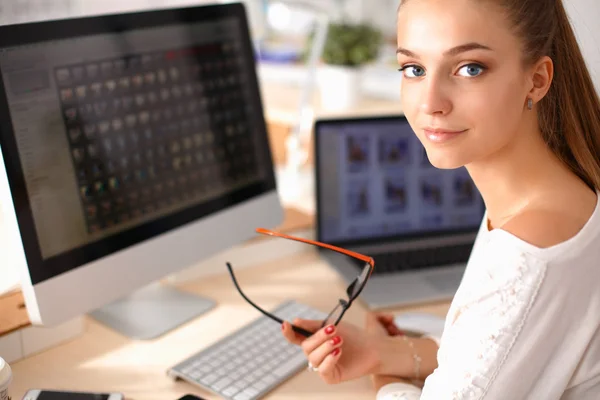 Jonge vrouw werkt in het kantoor, zit aan het bureau — Stockfoto