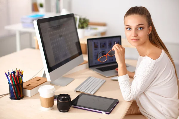 Jonge vrouw werkt in het kantoor, zit aan het bureau — Stockfoto