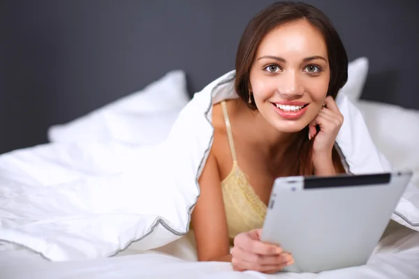 Le donne usano un tablet pc sul letto — Foto Stock