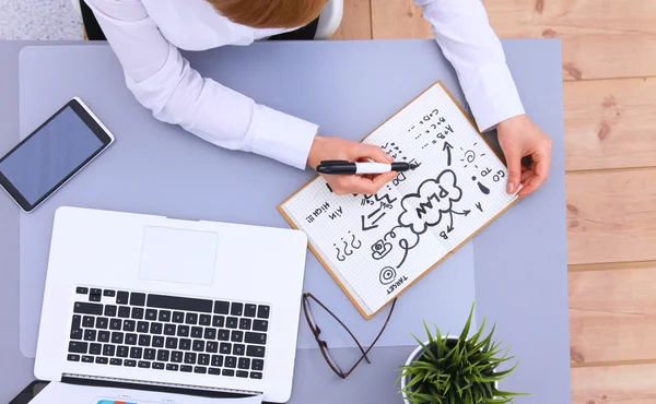 Young woman writes to diary on a white table — Stock Photo, Image