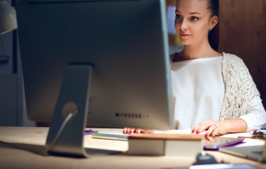 Ofiste çalışan genç kadın masada oturan ve telefonda konuşmak