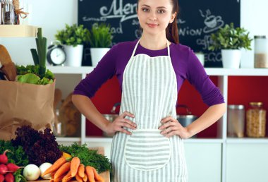 Onun mutfak masa alışveriş torbaları ile yakın duran genç kadın