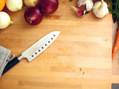 Mutfakta sebze doğrayan genç bir kadın.