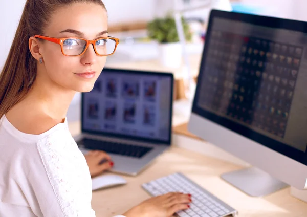 Junge Frau im Büro, am Schreibtisch sitzend — Stockfoto