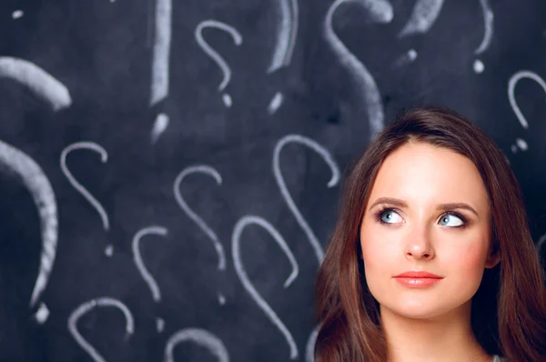 Jeune fille avec point d'interrogation sur un fond gris — Photo