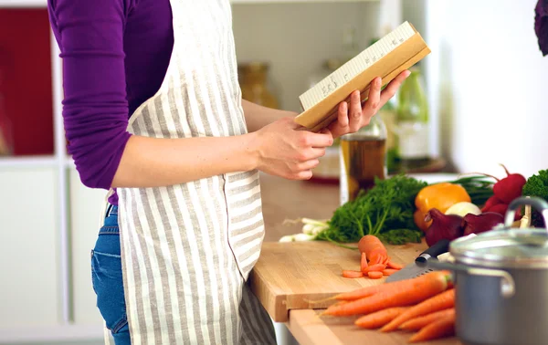 Fiatal nő vágás zöldségek a konyhában — Stock Fotó