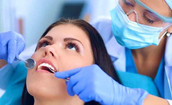 Mulher dentista trabalhando em seus pacientes dentes — Fotografia de Stock