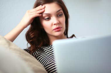 Koltukta oturan dizüstü kullanan mutlu güzel kadın