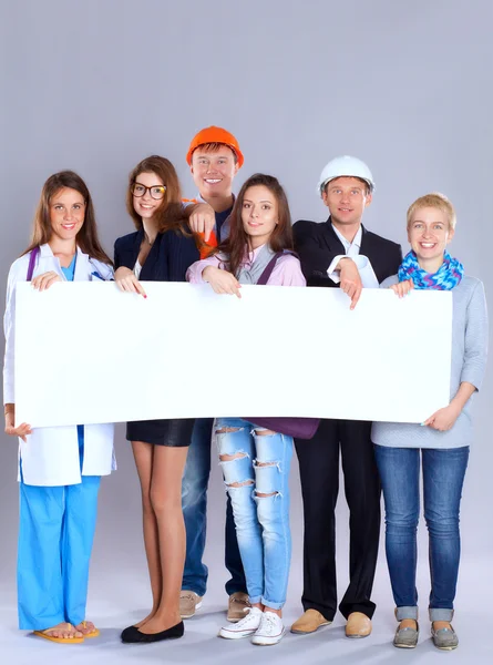 Portrait of smiling people with various occupations holding blank billboard