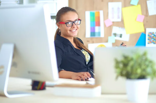 Mujer joven trabajando en la oficina, sentada en el escritorio — Foto de Stock