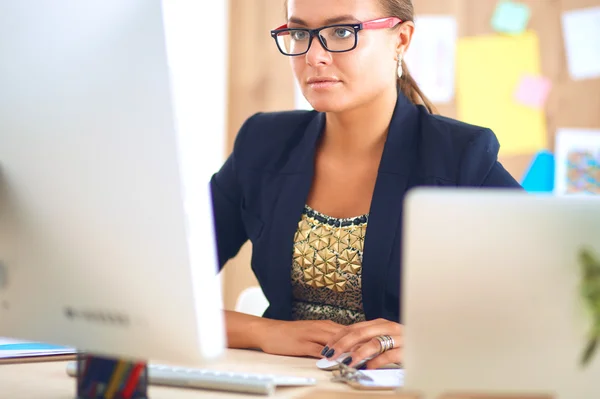 Modedesigner, die im Atelier arbeiten, sitzen am Schreibtisch — Stockfoto