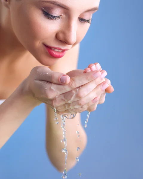 Wanita muda mencuci wajahnya dengan air jernih — Stok Foto