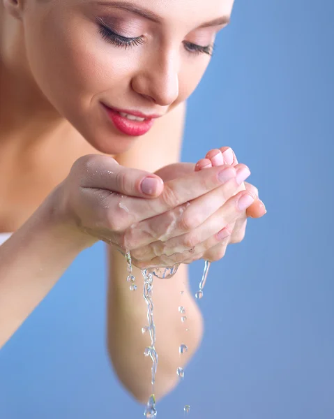 Mujer joven lavándose la cara con agua clara —  Fotos de Stock