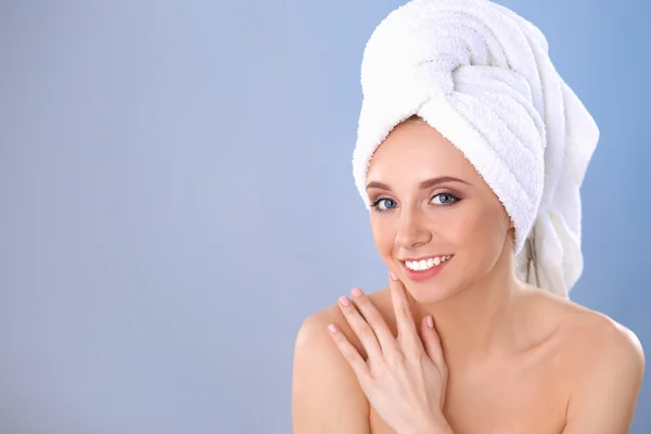 Piękna kobieta z ręcznikiem na głowie na szarym tle — Zdjęcie stockowe