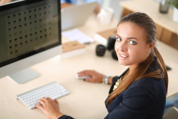 Jonge vrouw werkt in het kantoor, zit aan het bureau — Stockfoto